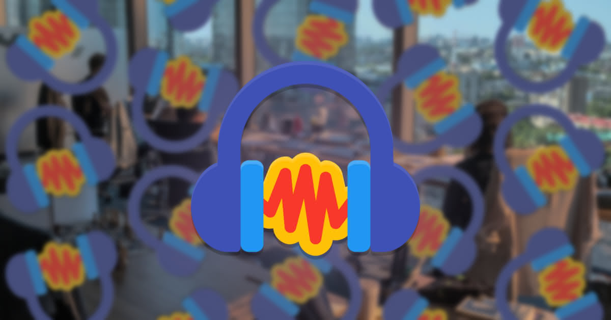 The application icon for "Audacity", Papirus style, shown in front of a blurred office background