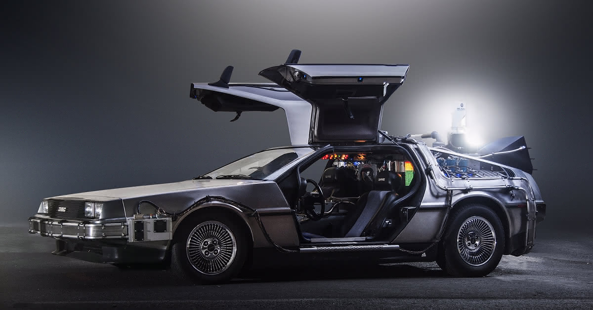The fictional car and time machine "DeLorean DMC-12", winged doors spun open, set against a dark gray background.